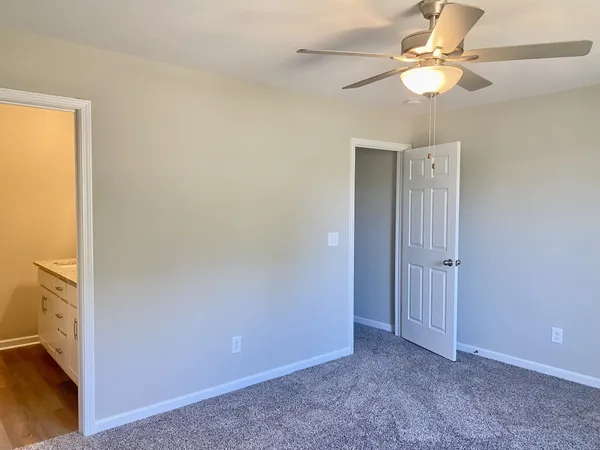 an empty room with a ceiling fan and a window