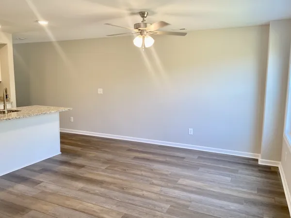 a view of a room with wooden floor and a ceiling fan
