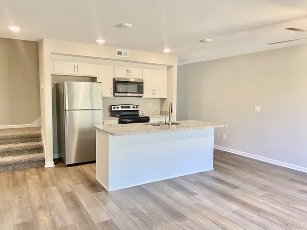 a kitchen with stainless steel appliances a refrigerator stove and microwave