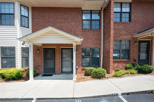 a view of a brick house with potted plants