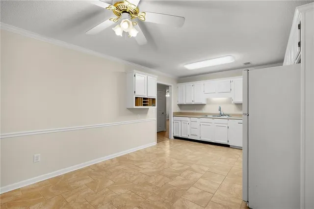 a kitchen with white cabinets and white stainless steel appliances