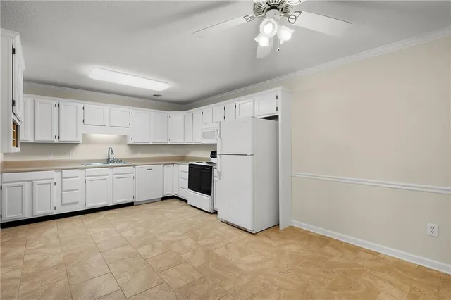 a kitchen with granite countertop white cabinets and white appliances