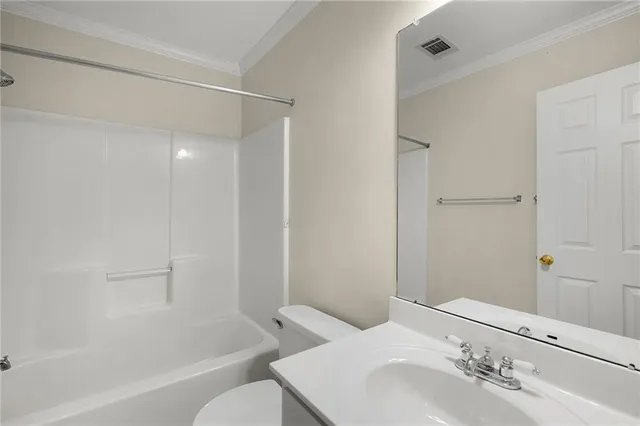 a bathroom with a bathtub shower sink vanity and toilet