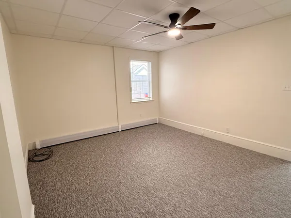 an empty room with a window and a ceiling fan