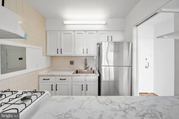 a kitchen with stainless steel appliances a refrigerator and a stove top oven