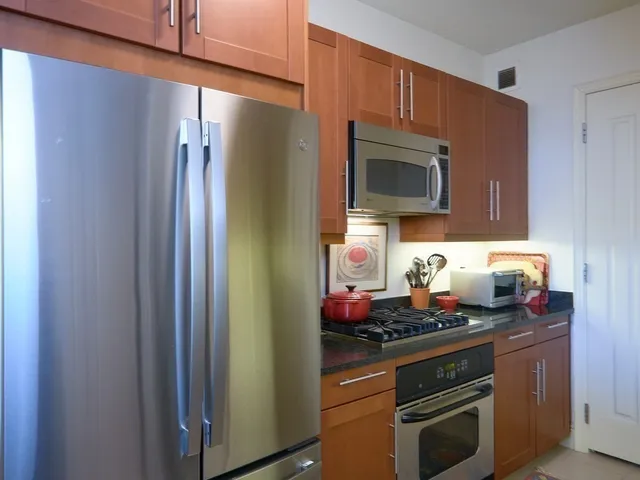 a kitchen with stainless steel appliances granite countertop a refrigerator stove and microwave