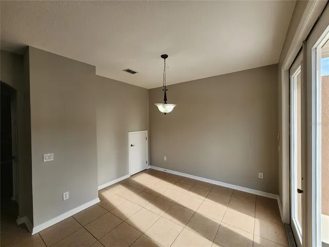 a view of a room with a hanging light and kitchen