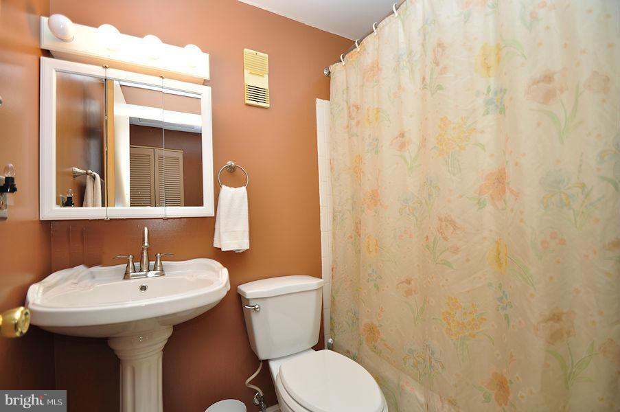 4813 Vicky Road Baltimore, MD 21236 - Photo 18 of 22 a bathroom with a sink a toilet and shower curtain