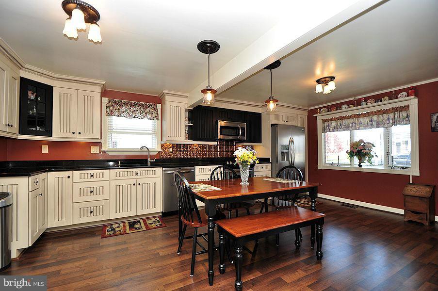 4813 Vicky Road Baltimore, MD 21236 - Photo 8 of 22 a kitchen with a table chairs stove and cabinets