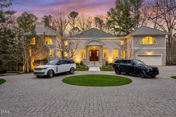 a view of a street with cars parked in front of a house