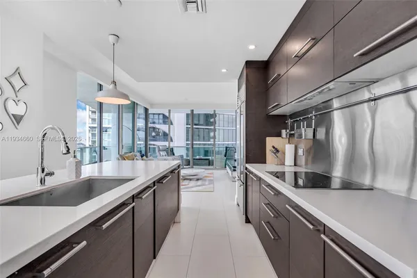 a view of a kitchen with stainless steel appliances granite countertop a sink and a refrigerator