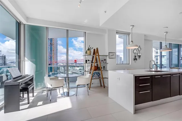 a living room with furniture a bookshelf and a large window