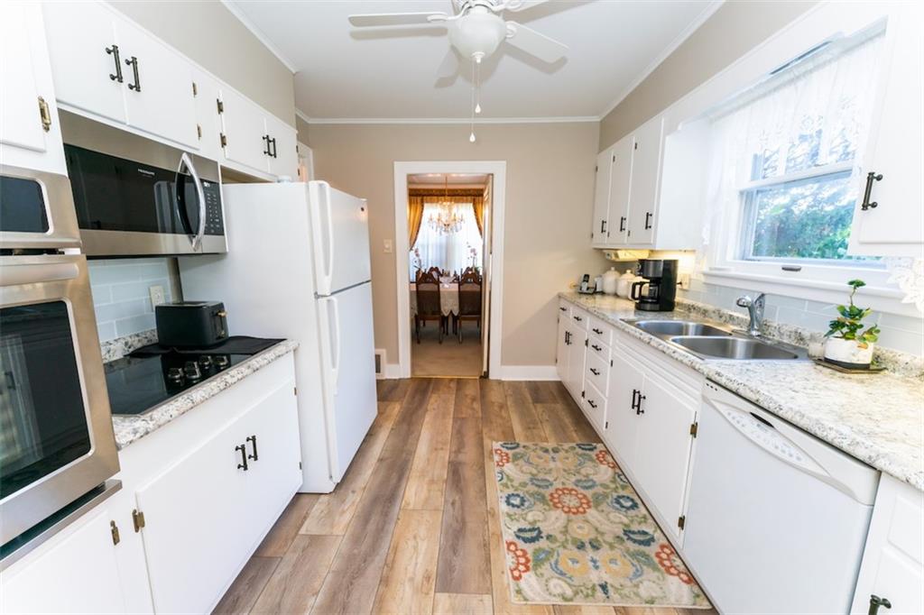 707 South 6th Street Indiana, PA 15701 - Photo 4 of 16 a large white kitchen with stainless steel appliances a stove a refrigerator a sink dishwasher and white cabinets with wooden floor