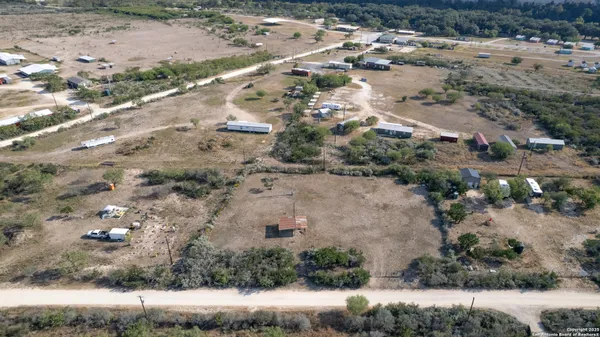 a view of a dry yard with green space
