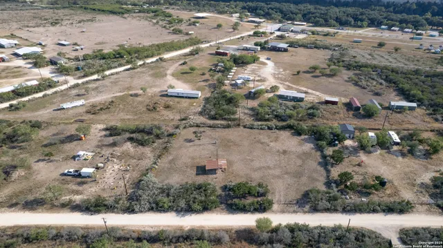 a view of a dry yard with green space