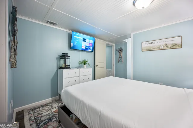 a bedroom with a bed and a flat screen tv