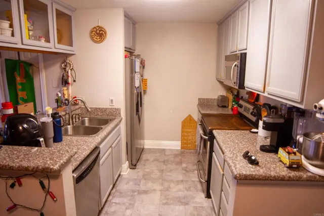 a kitchen with granite countertop a sink and a stove top oven