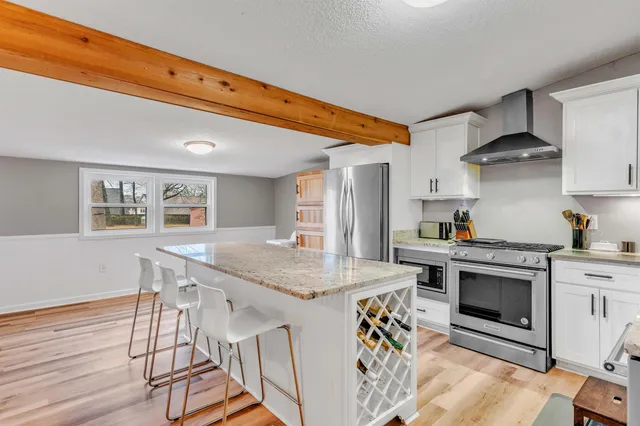 a kitchen with stainless steel appliances granite countertop a stove a sink and a refrigerator