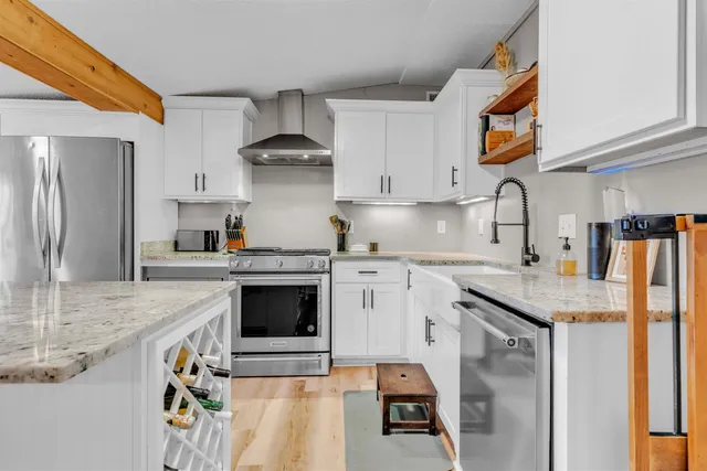 a kitchen with stainless steel appliances granite countertop a stove a sink and a refrigerator