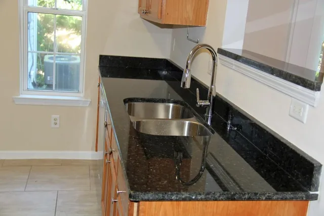 a kitchen with granite countertop wood cabinets and stainless steel appliances