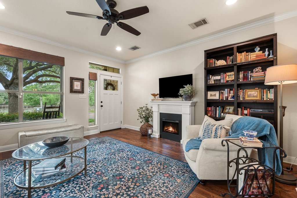 6708 Menchaca Road, Unit 2 Austin, TX 78745 - Photo 6 of 30 Bright living area featuring wood-finish flooring, a white mantel fireplace, and a built-in dark wood bookcase
