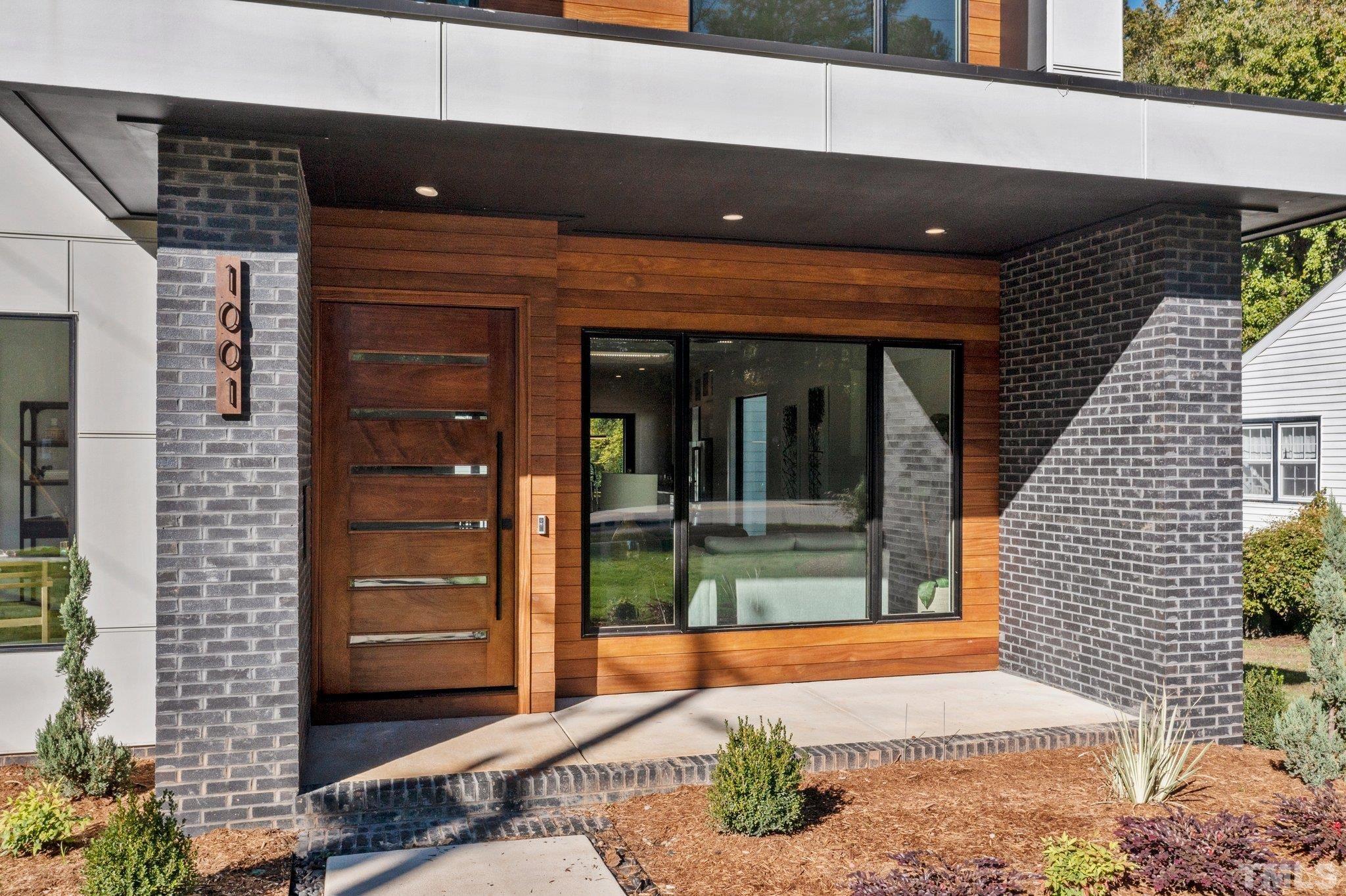 1001 North State Street Raleigh, NC 27604 - Photo 4 of 30 No details spared - enter through a large wooden pivot door, juxtaposed by a large Pella aluminum clad window to allow maximum natural light and a natural indoor/outdoor flow.