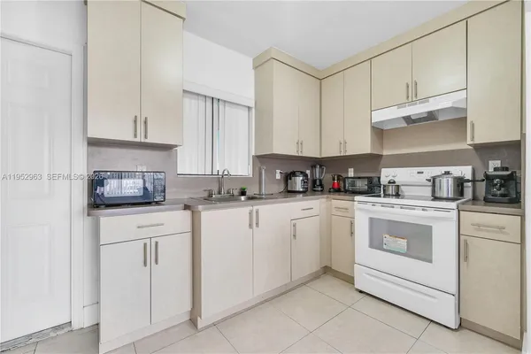 a kitchen with cabinets appliances a sink and a counter top