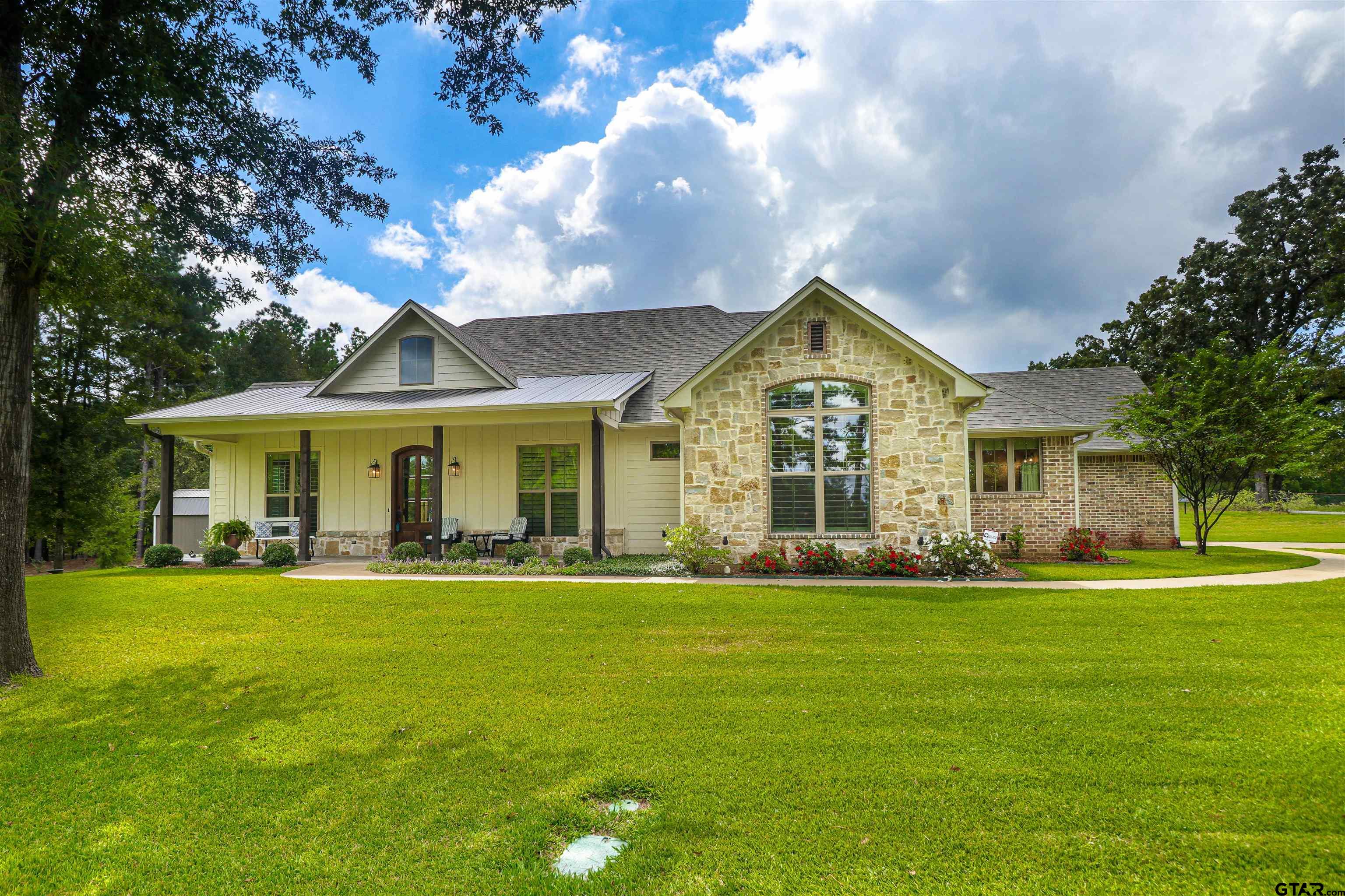 a view of a house with a big yard and large trees