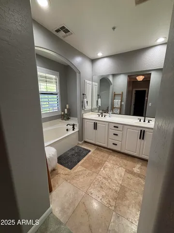 a large bathroom with a sink a large mirror and bathtub