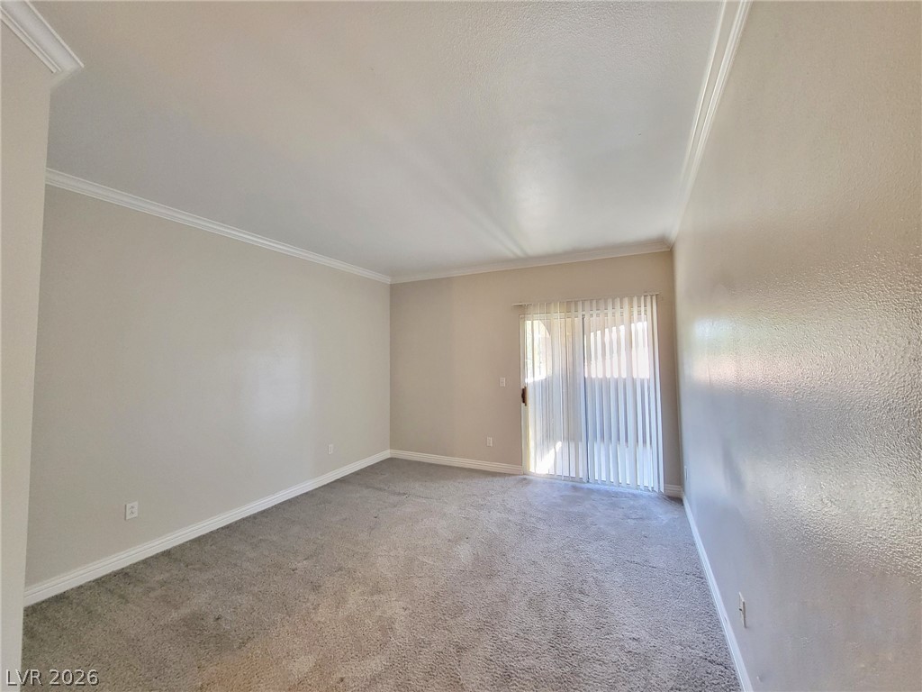 5525 West Flamingo Road, Unit 2040 Las Vegas, NV 89103 - Photo 11 of 15 Step into a generously proportioned living room featuring crown molding and sliding glass doors.