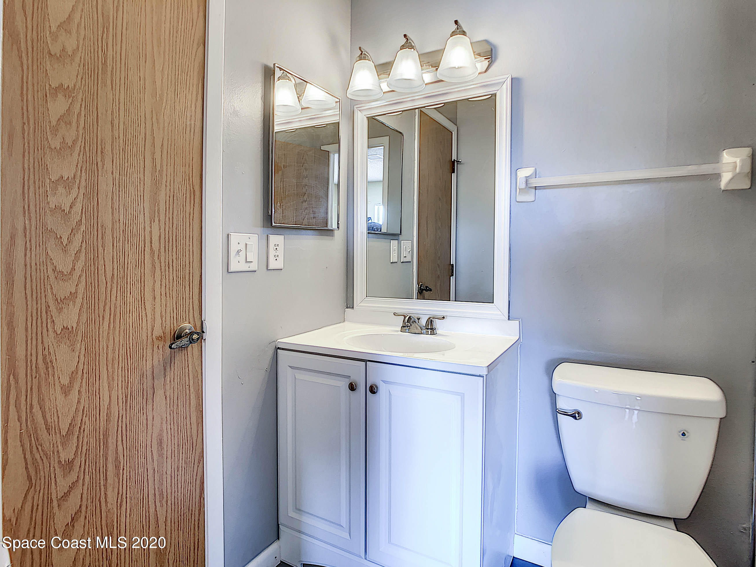 1882 Murrell Road, Unit 44 Rockledge, FL 32955 - Photo 14 of 27 a bathroom with a toilet a sink and mirror