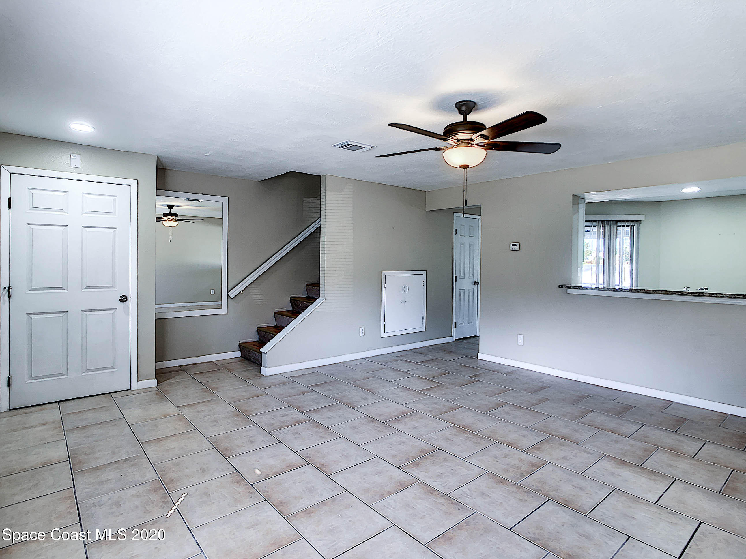 1882 Murrell Road, Unit 44 Rockledge, FL 32955 - Photo 5 of 27 an empty room with a ceiling fan and glass door