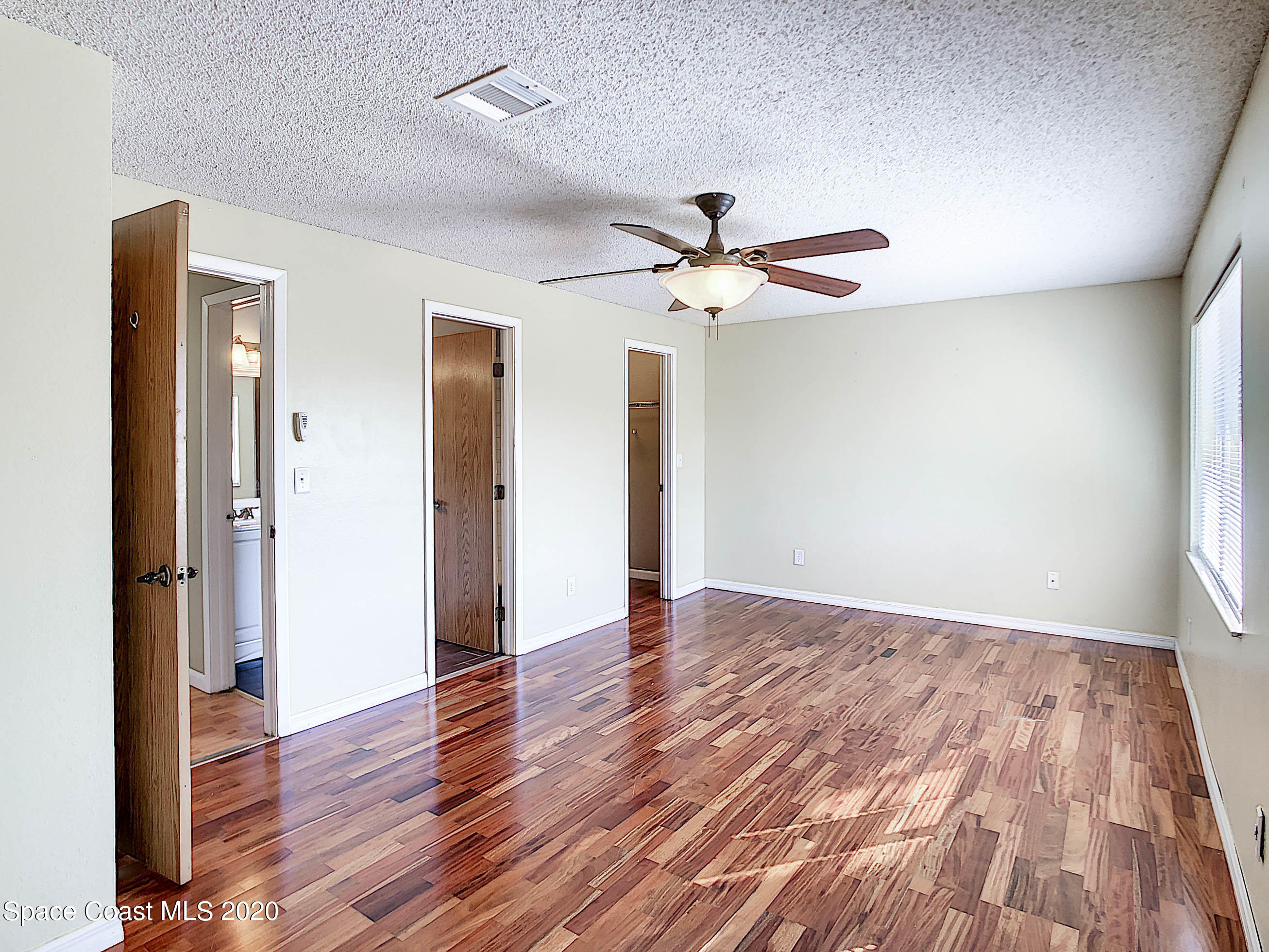 1882 Murrell Road, Unit 44 Rockledge, FL 32955 - Photo 9 of 27 an empty room with wooden floor and a ceiling fan