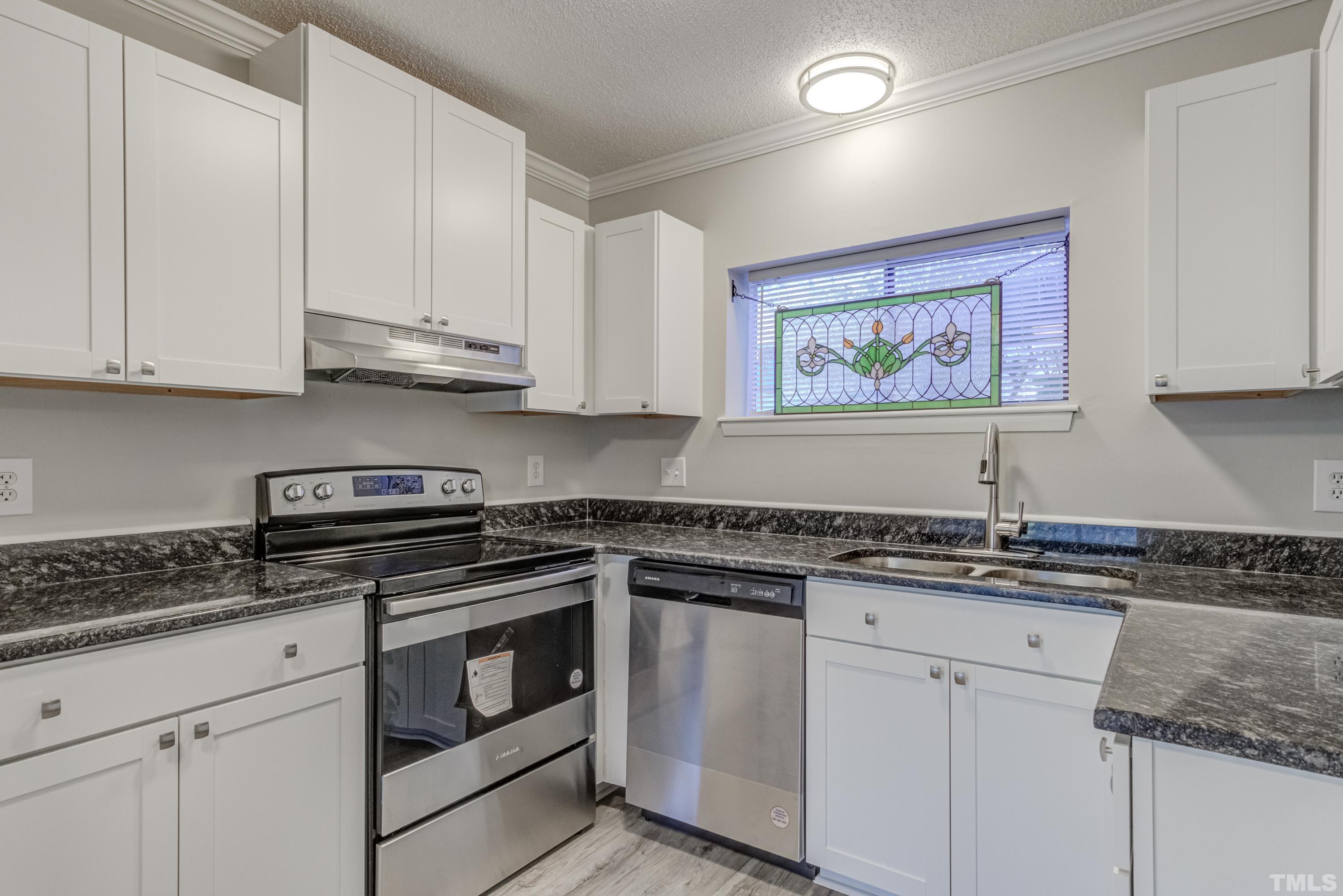 722 Godwin Court Raleigh, NC 27606 - Photo 28 of 41 a kitchen with stainless steel appliances granite countertop a sink and cabinets