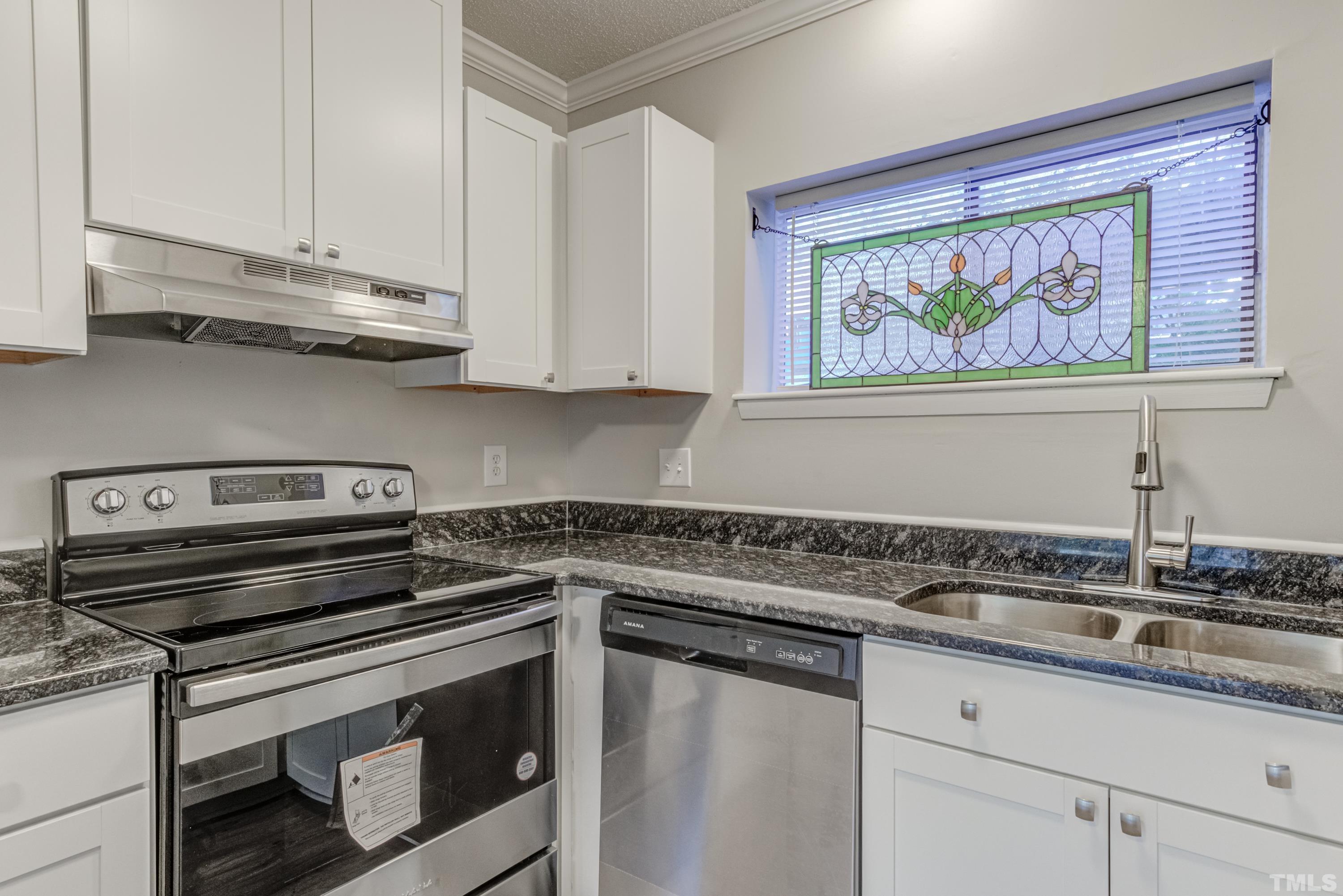 722 Godwin Court Raleigh, NC 27606 - Photo 29 of 41 a kitchen with stainless steel appliances granite countertop a sink a stove and cabinets