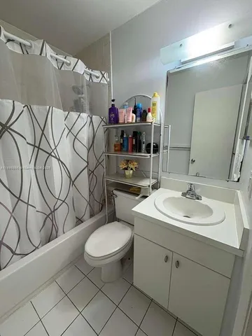 a bathroom with a toilet and a shower curtain