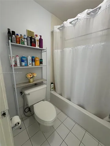 a spacious bedroom with a bed a couch and a chandelier