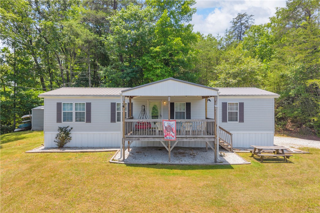 334 Lake Becky Road Mountain Rest, SC 29664 - Photo 1 of 46 An inviting covered porch offers a warm welcome to this charming single-story residence amidst lush greenery.