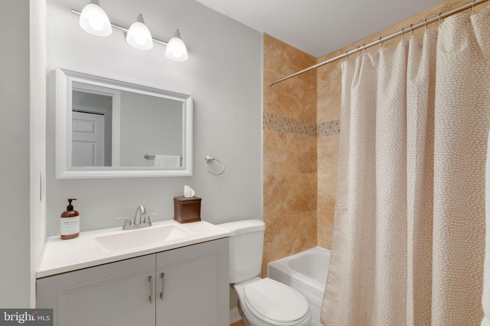 5 Winesap Court Gaithersburg, MD 20878 - Photo 32 of 44 a bathroom with a sink a toilet and shower curtain