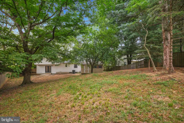 a front view of house with yard and trees in the background