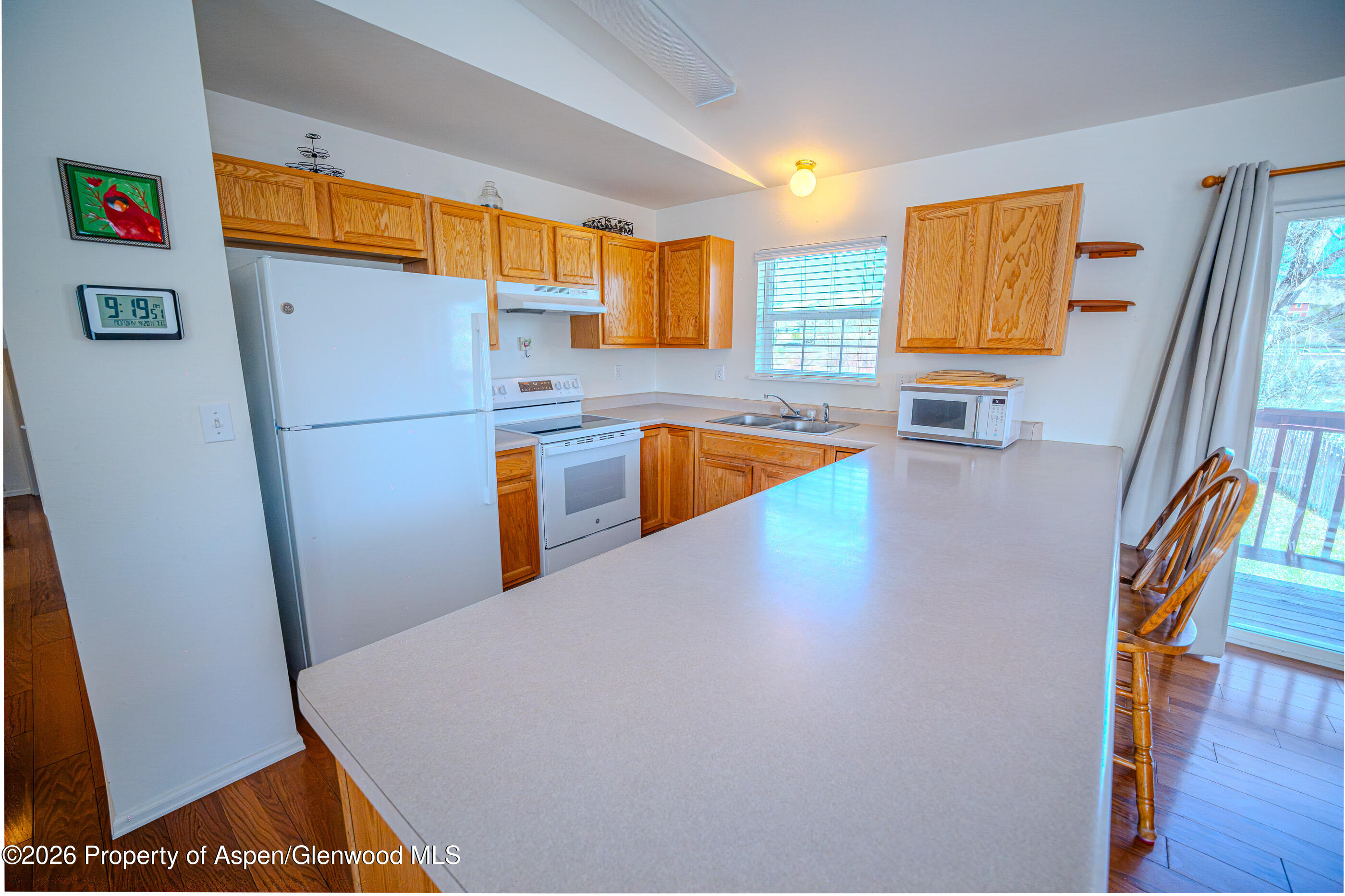 2319 Meadow Circle Rifle, CO 81650 - Photo 4 of 33 a kitchen with stainless steel appliances a refrigerator a sink a stove a microwave a counter top and a dining table