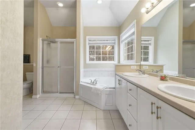 a spacious bathroom with a granite countertop sink a mirror and a bathtub