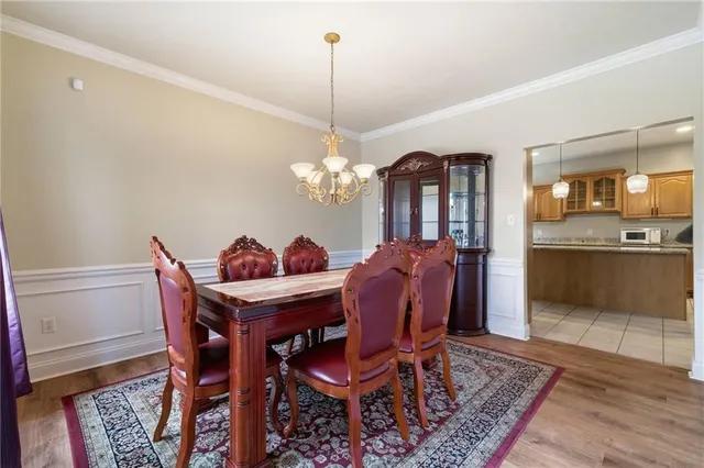 a dining room with furniture a chandelier and wooden floor