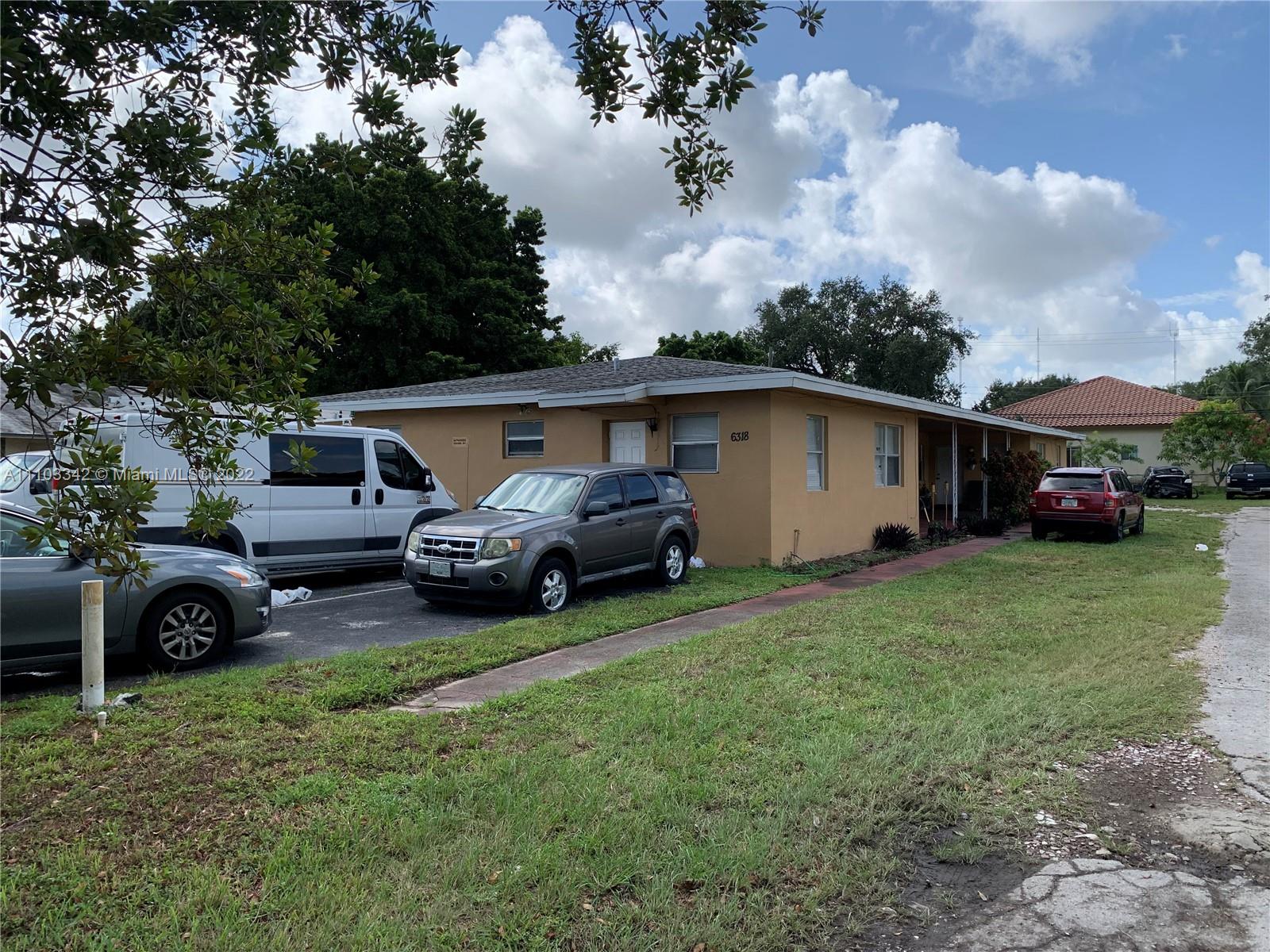 6318 Southwest 25th Street Miramar, FL 33023 - Photo 3 of 6 a front view of a house with a garden and trees
