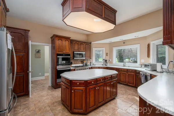 a kitchen with stainless steel appliances granite countertop a stove a sink and a refrigerator