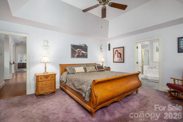 a spacious bedroom with a bed and a chandelier