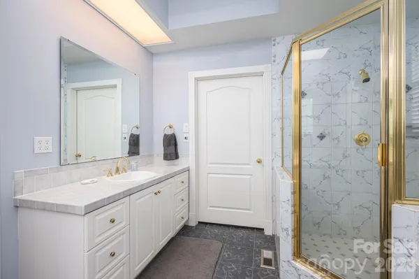 a spacious bathroom with a shower sink and mirror