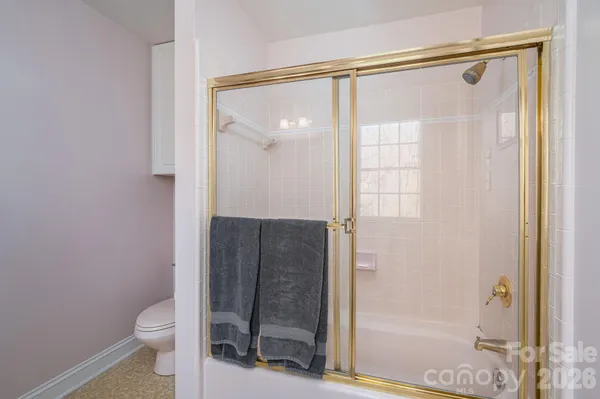 a bathroom with a granite countertop bathtub shower and toilet