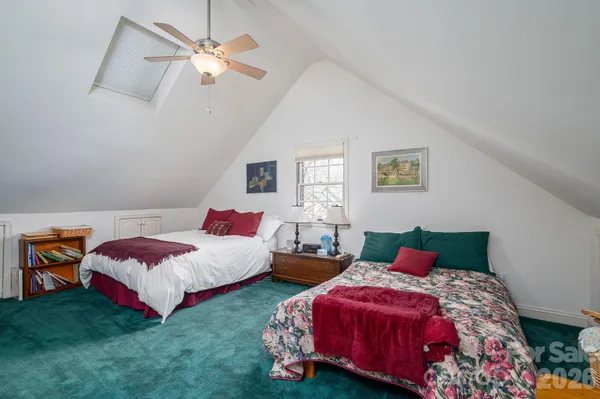 a bedroom with two beds and a chandelier