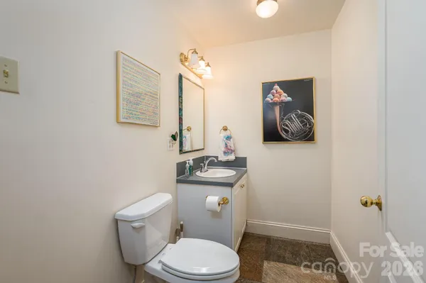 a white toilet sitting next to a bathroom sink and vanity